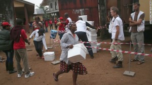 Los residentes de un municipio afectado por Ebola toman los materiales y utensilios caseros distribuidos por Médicos Sin Fronteras, el sábado 4 de octubre en Nueva Kru Town, Liberia. Los kits, que incluyen cubos, jabón, guantes, batas anticontaminación, bolsas de plástico, una botella de spray y máscaras, tienen el propósito de dar a la gente un cierto nivel de protección si un miembro de la familia se enferma. (John Moore Getty Images) CNN Library